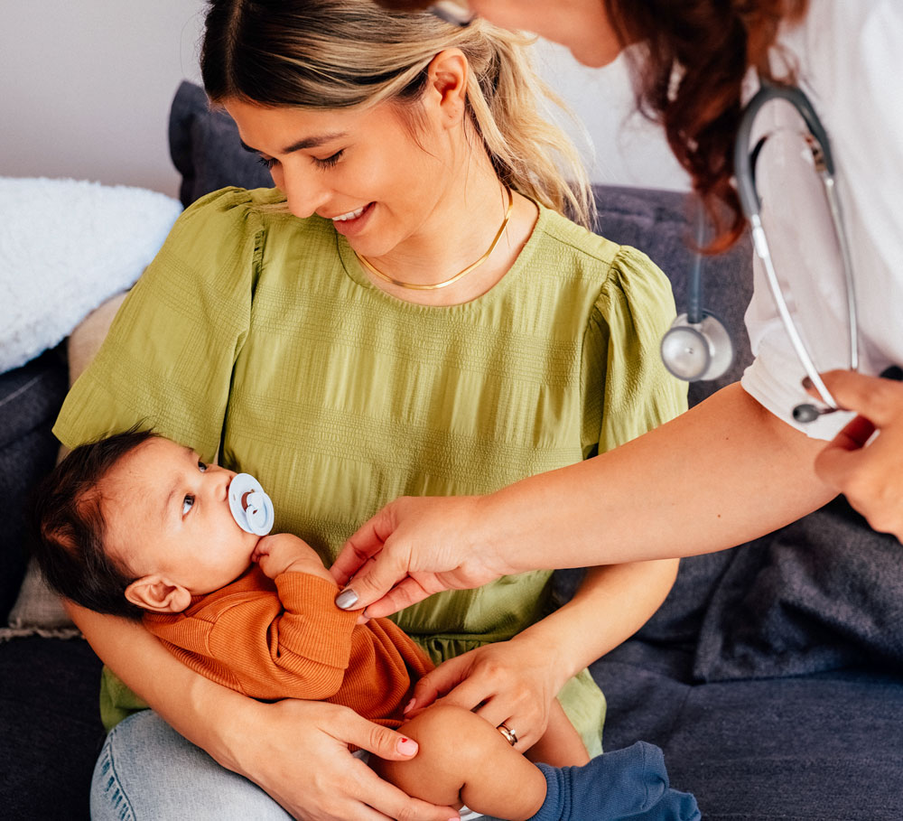 Mother holds baby during doctors check-up