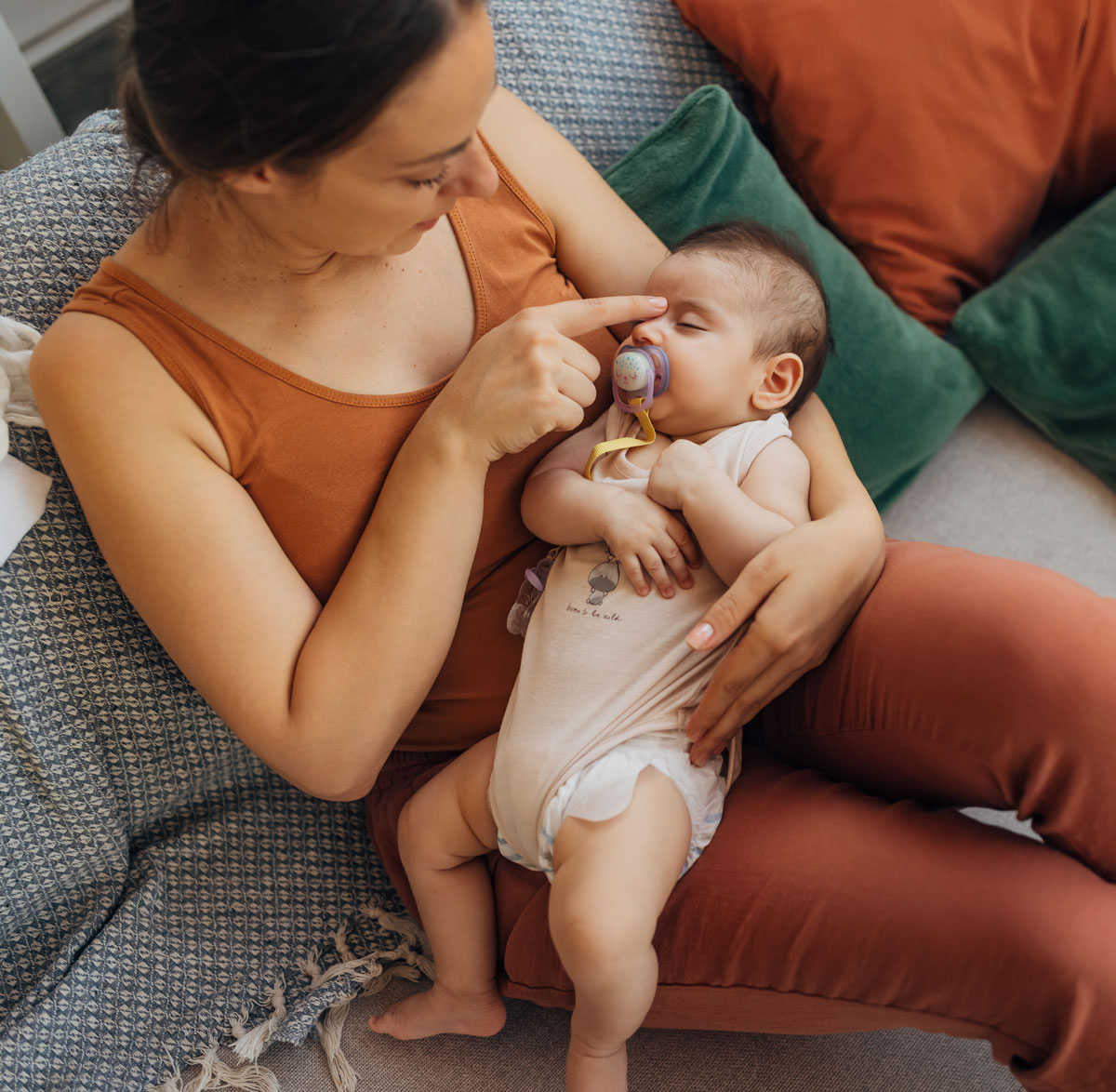 Mother gently holding baby with pacifier