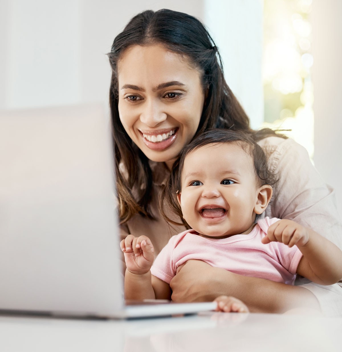 Smiling mother and baby looking at laptop together
