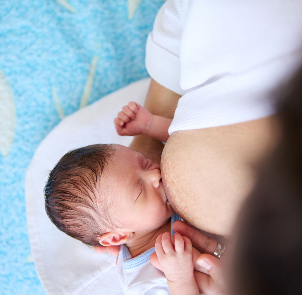 Newborn breastfeeding from above, close-up view
