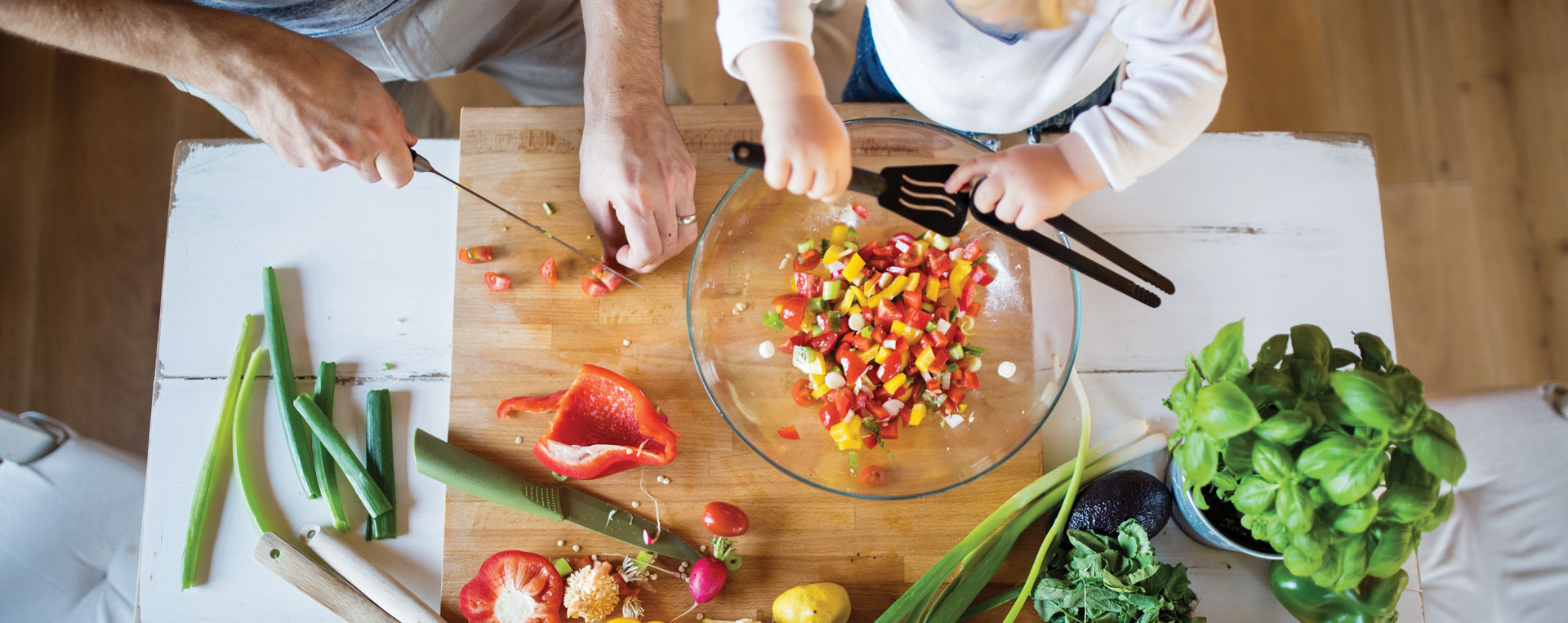 Father and child chopping vegetables for salad