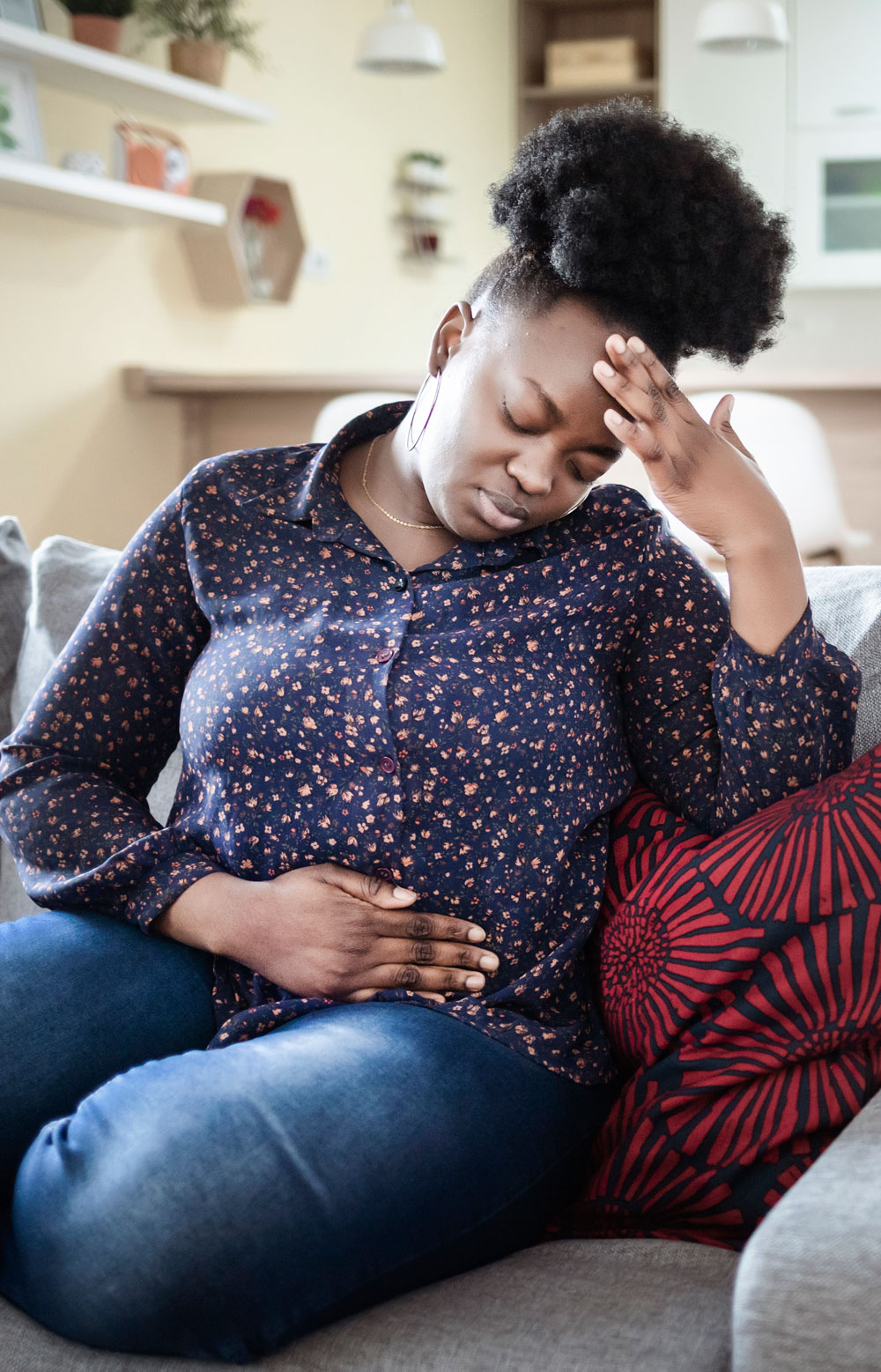 Woman-with-stomachache-looking-unwell-on-couch