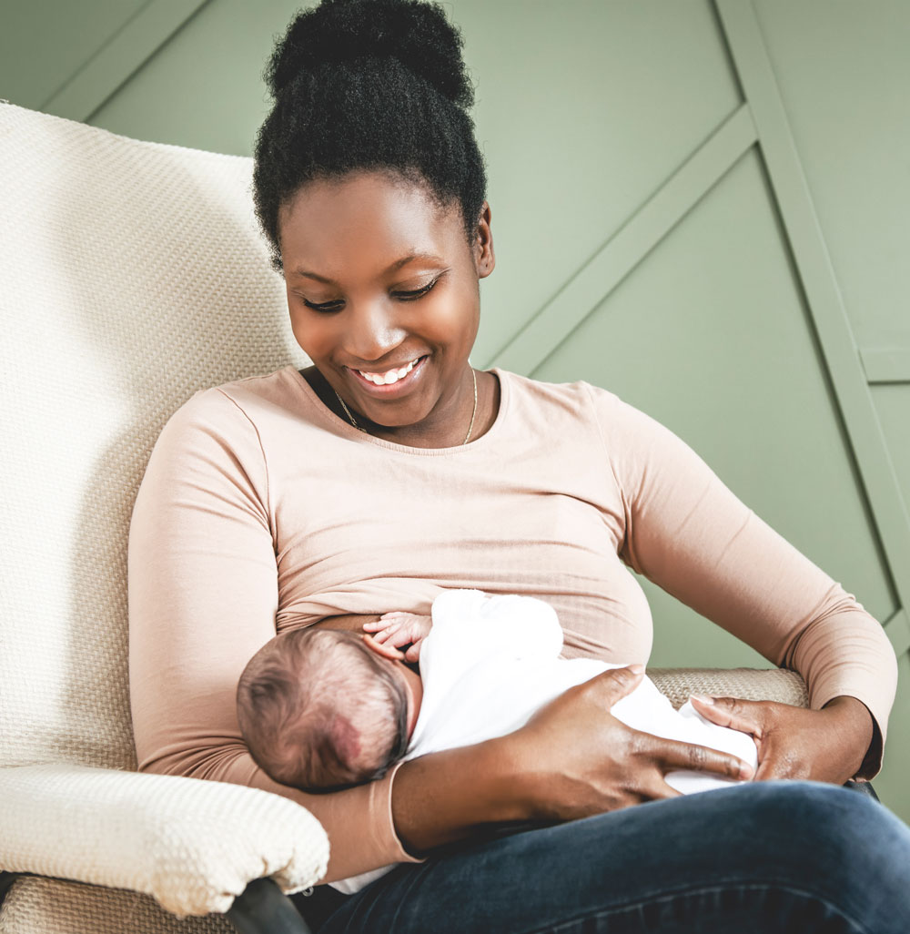 Woman sitting in chair, holding her baby