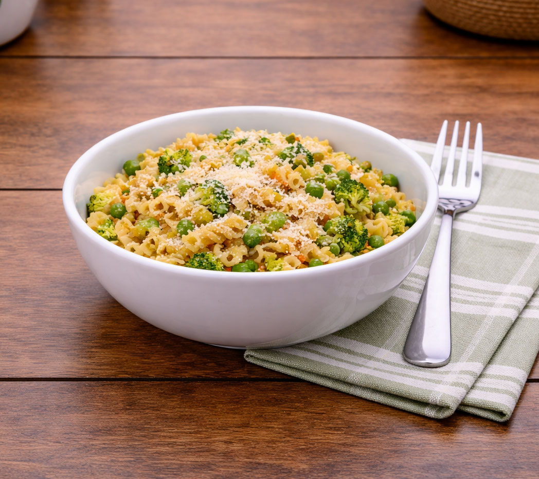 Pasta with broccoli and peas in a white bowl