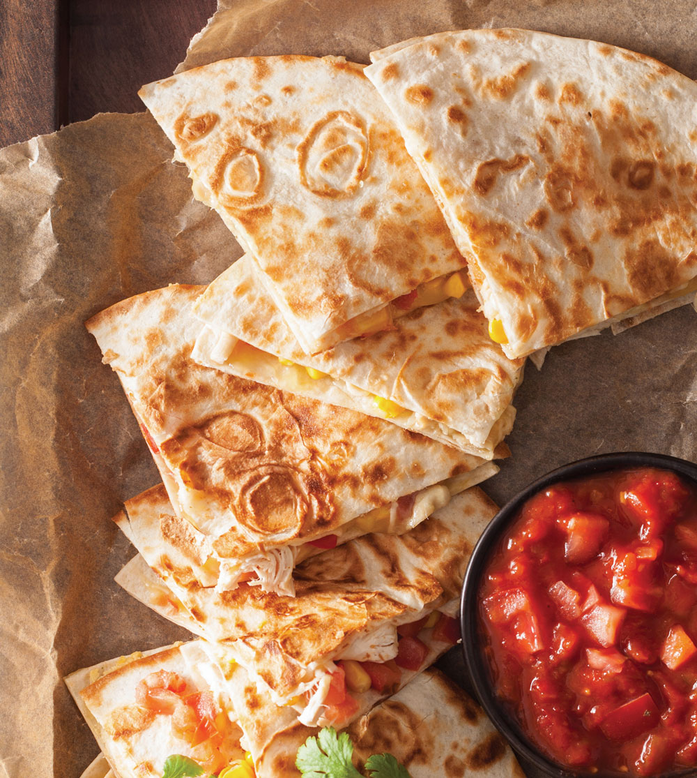 Quesadillas with salsa on parchment paper.