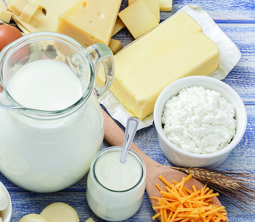 Assorted dairy products on a wooden surface.