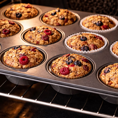 Muffins with berries baking in the oven.