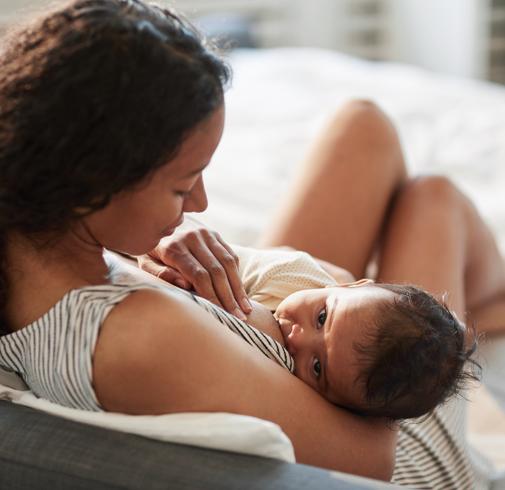 Mother breastfeeding infant in a comfortable setting