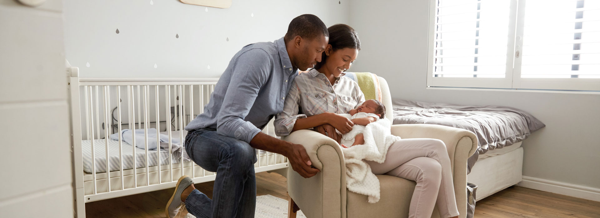 Parents cuddling newborn in cozy nursery chair