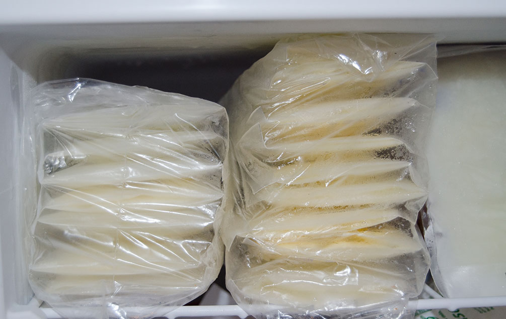 Frozen milk storage bags stacked in a freezer