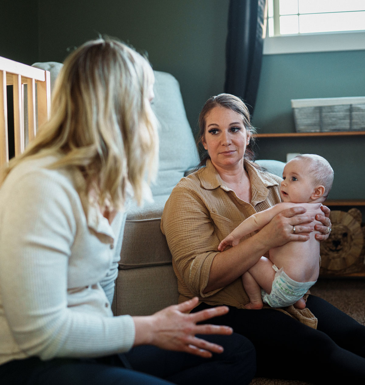 Lactation counselor converses with mother holding baby