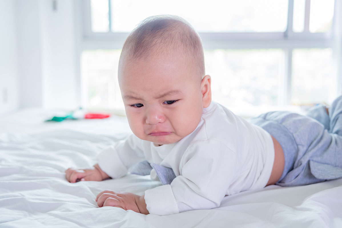 crying baby in bed