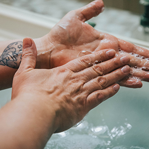 Hands washing with soap at sink