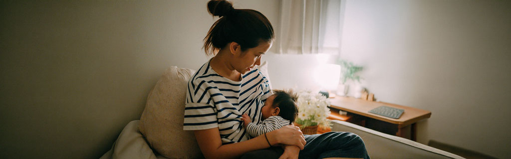 Mother breastfeeding baby in cozy, softly lit room