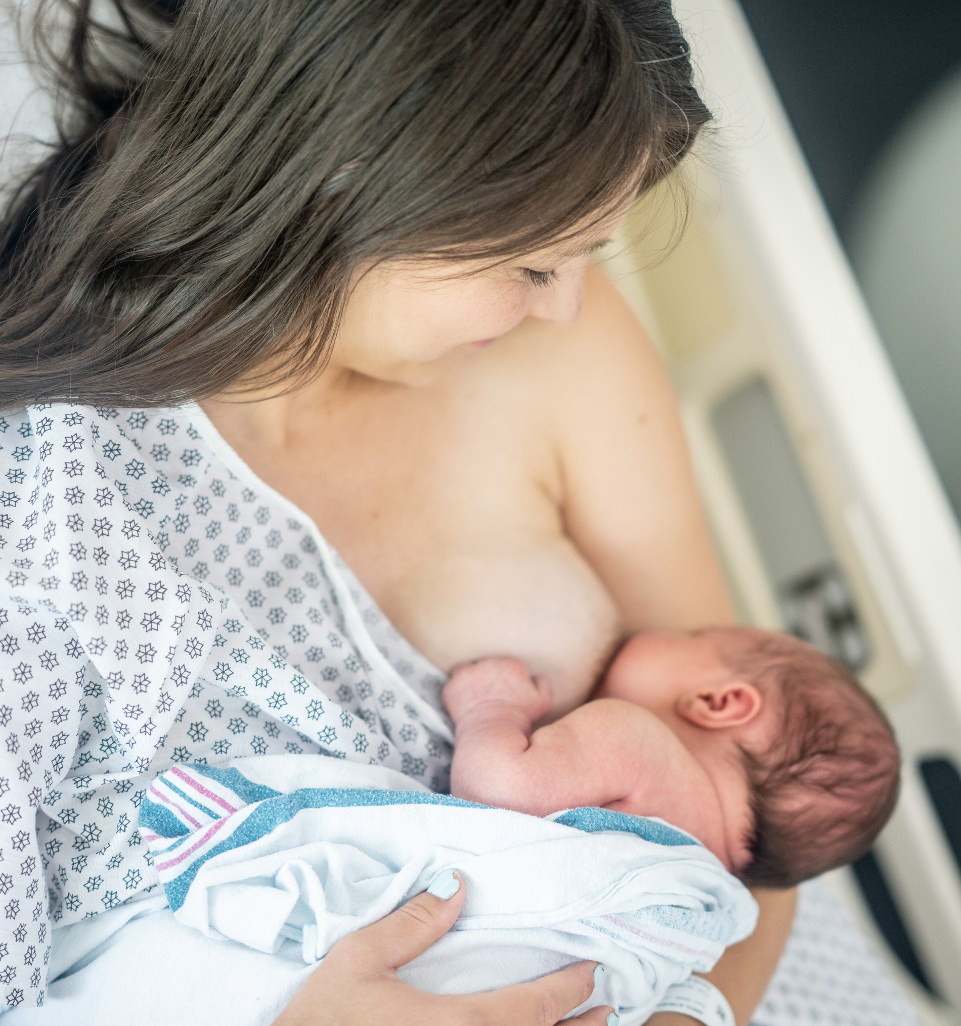 breastfeeding mother that is breastfeeding a newborn (smaller) baby